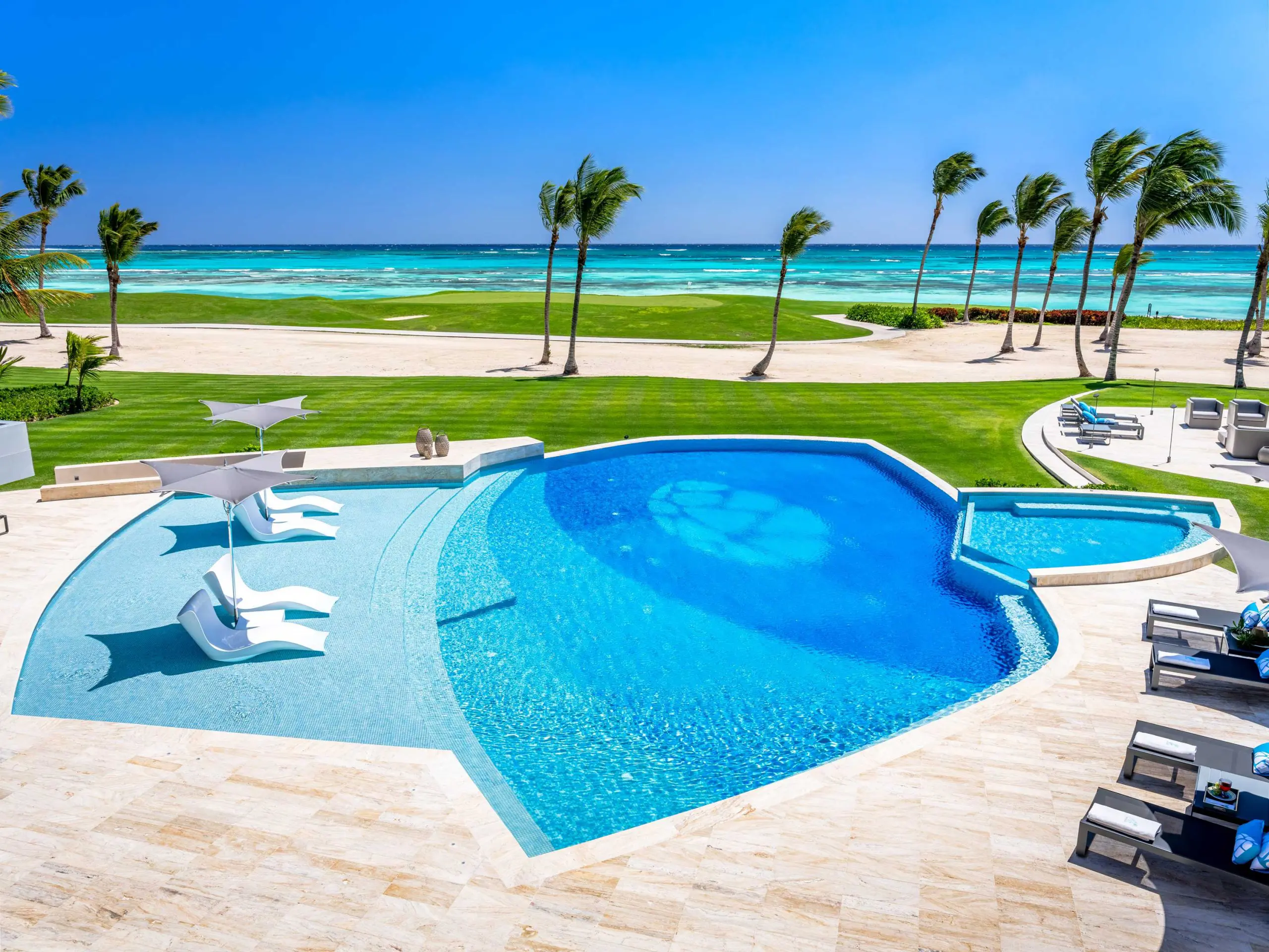 Shot from the pool area overlooking the palm trees before the crystal clear waters in the beach.