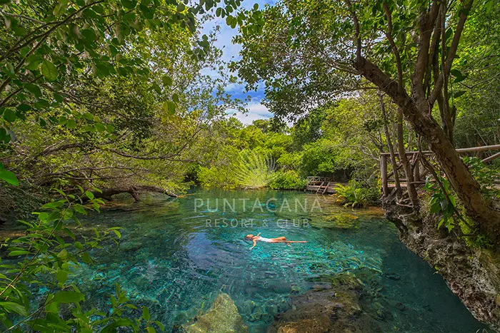 Picture of a woman floating in the clear waters of Ojos Indigenas Ecological Park and Reserve.